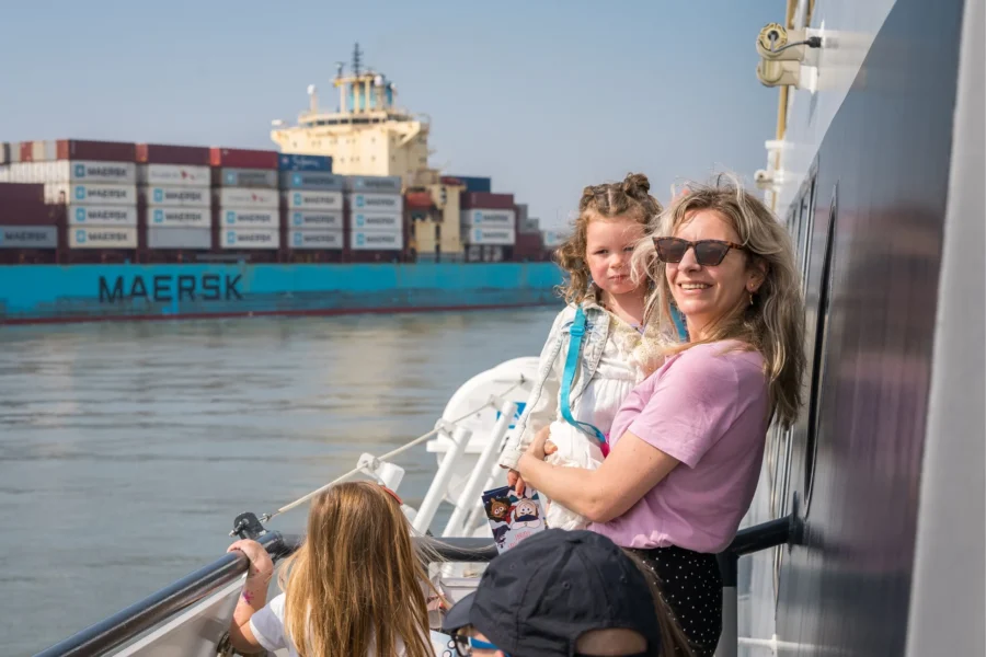 Passagiers aan boord van de Ferry die uitkijken op het water.